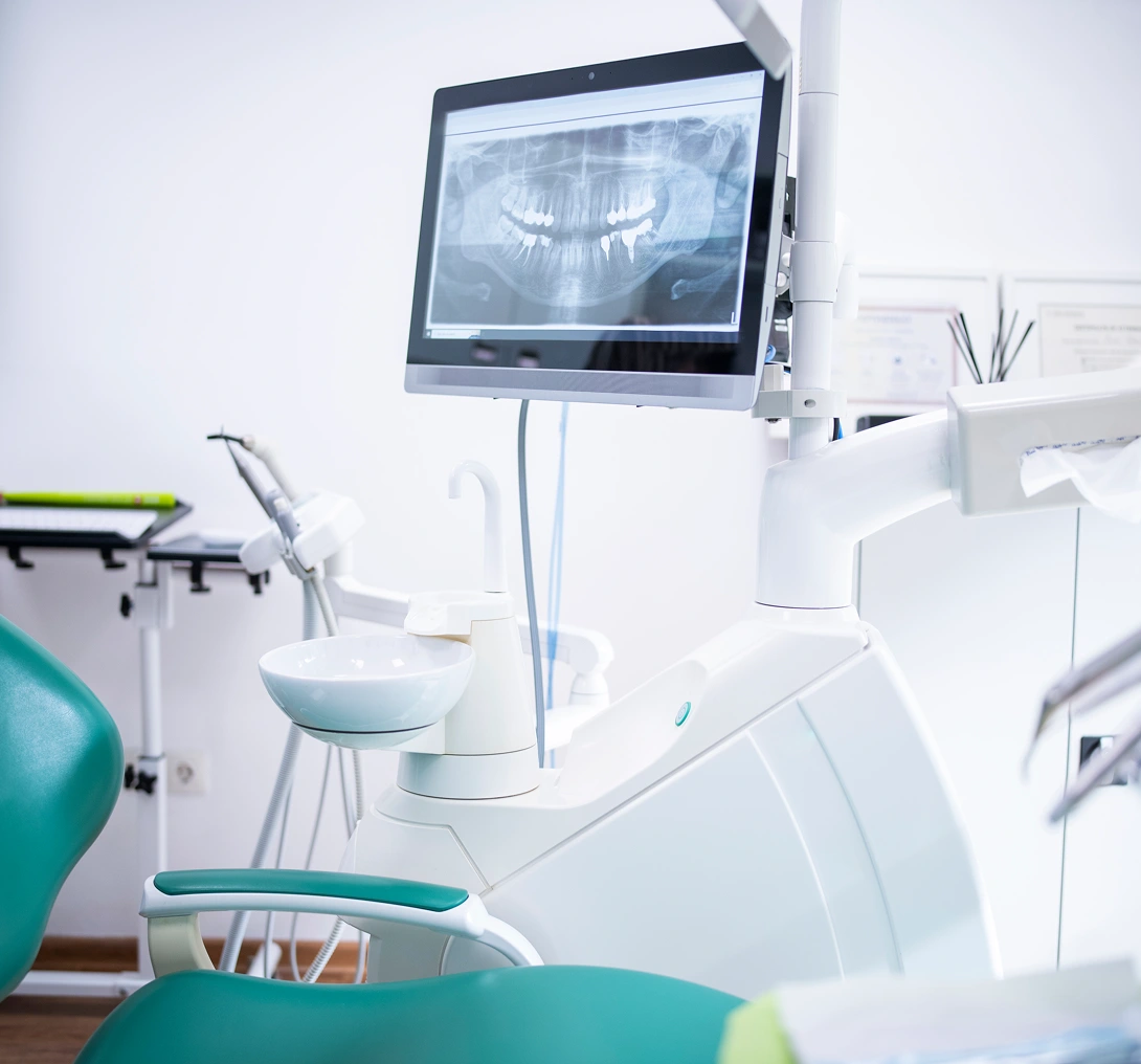 Dental chair with X-ray on monitor.
