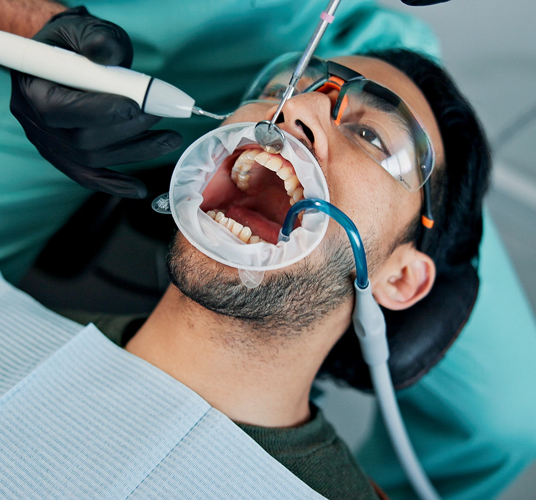 Patient receiving dental treatment with dental tools.