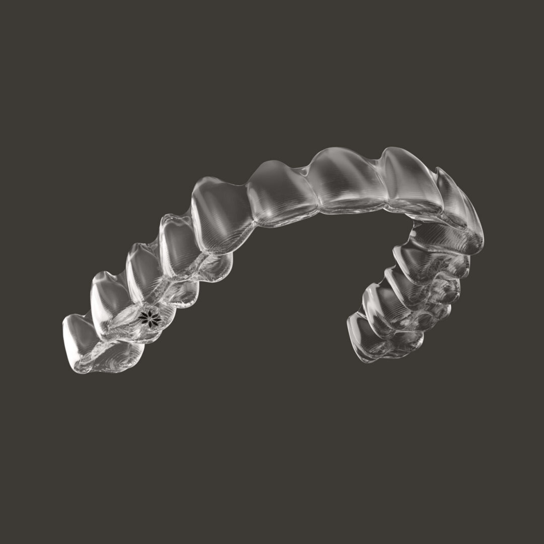 Clear dental aligner on dark background.
