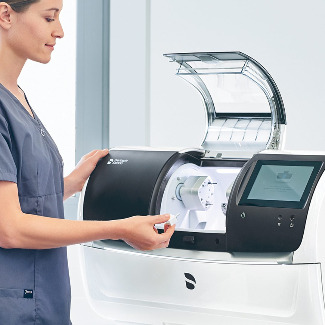 Person operating a dental milling machine.